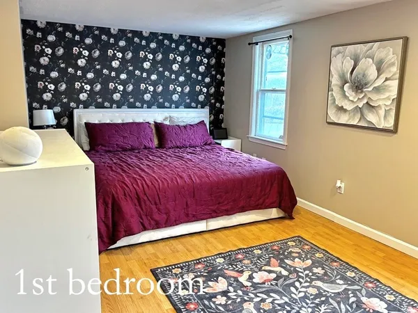 a bedroom with a bed and a painting on the wall