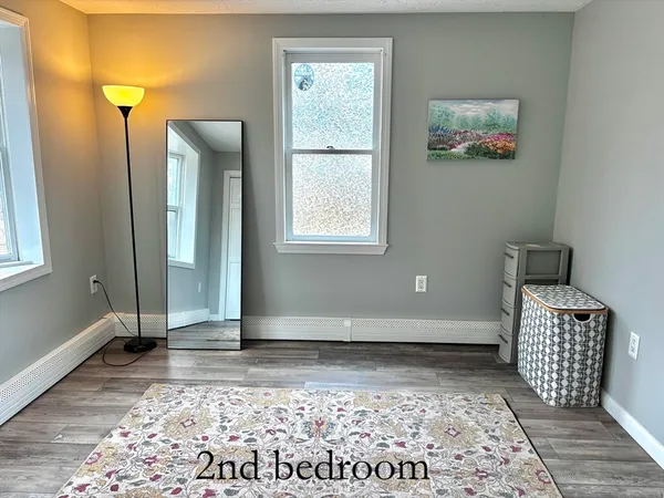 a bedroom with a bed and a mirror on dresser