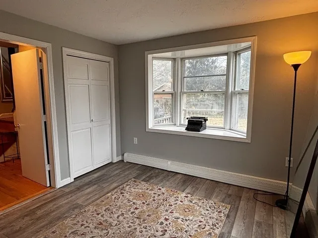 an empty room with wooden floor and a window