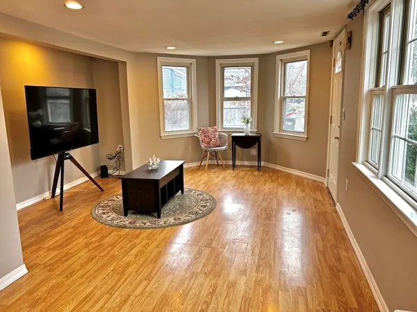 a living room with furniture a flat screen tv and windows