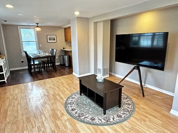 a living room with dining room and wooden floor