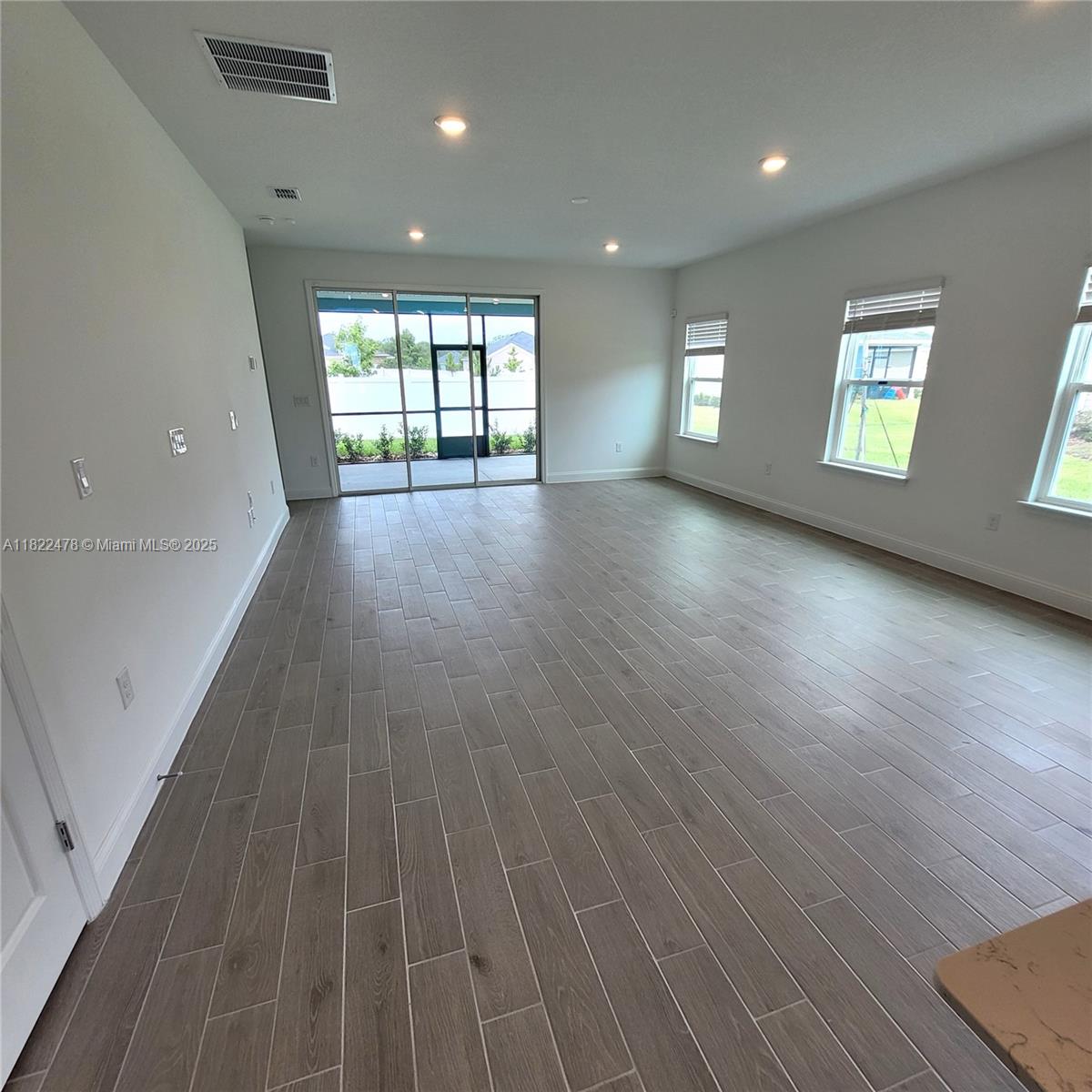 4155 Acoma Drive Ormond Beach, FL 32174 - Photo 19 of 49 an empty room with wooden floor and windows