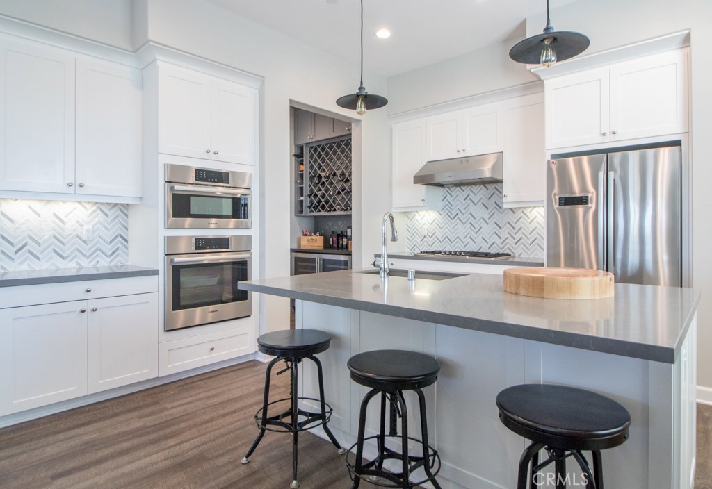 157 Follyhatch Irvine, CA 92618 - Photo 1 of 44 a kitchen with stainless steel appliances granite countertop a table chairs stove and cabinets