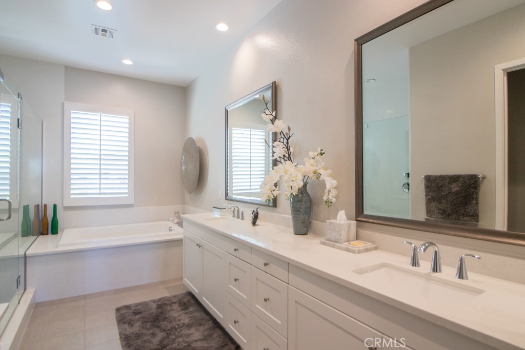 157 Follyhatch Irvine, CA 92618 - Photo 20 of 44 a bathroom with a double vanity sink bathtub and next to a window