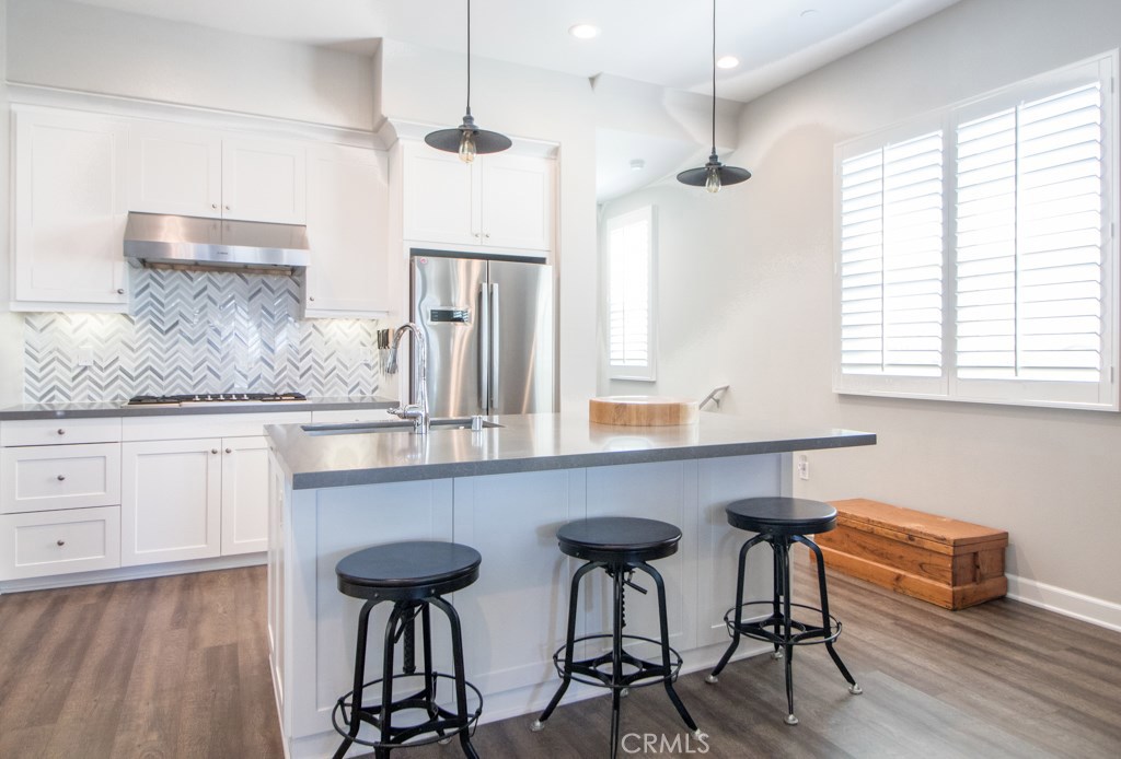 157 Follyhatch Irvine, CA 92618 - Photo 4 of 44 a kitchen with stainless steel appliances a table chairs refrigerator and sink