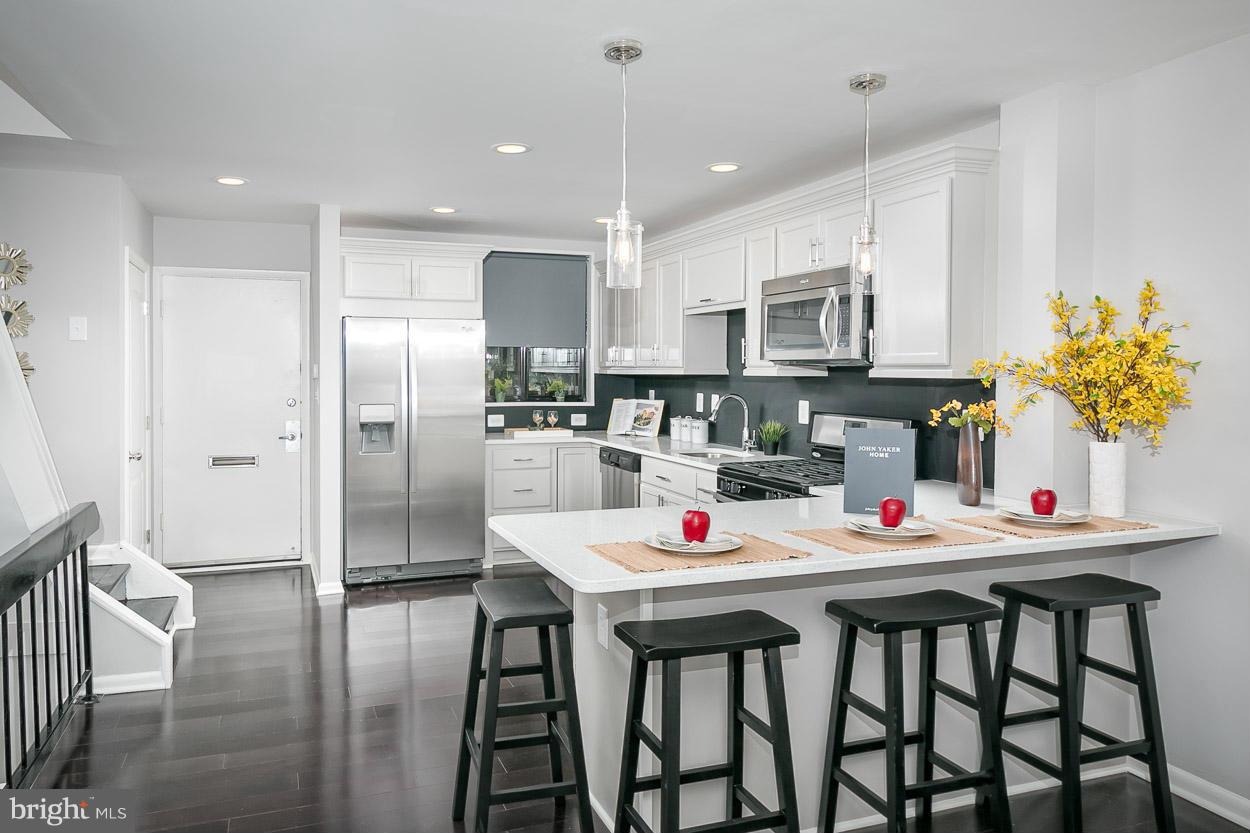 3 Cross Keys Road Baltimore, MD 21210 - Photo 10 of 29 a kitchen with kitchen island a refrigerator and a table