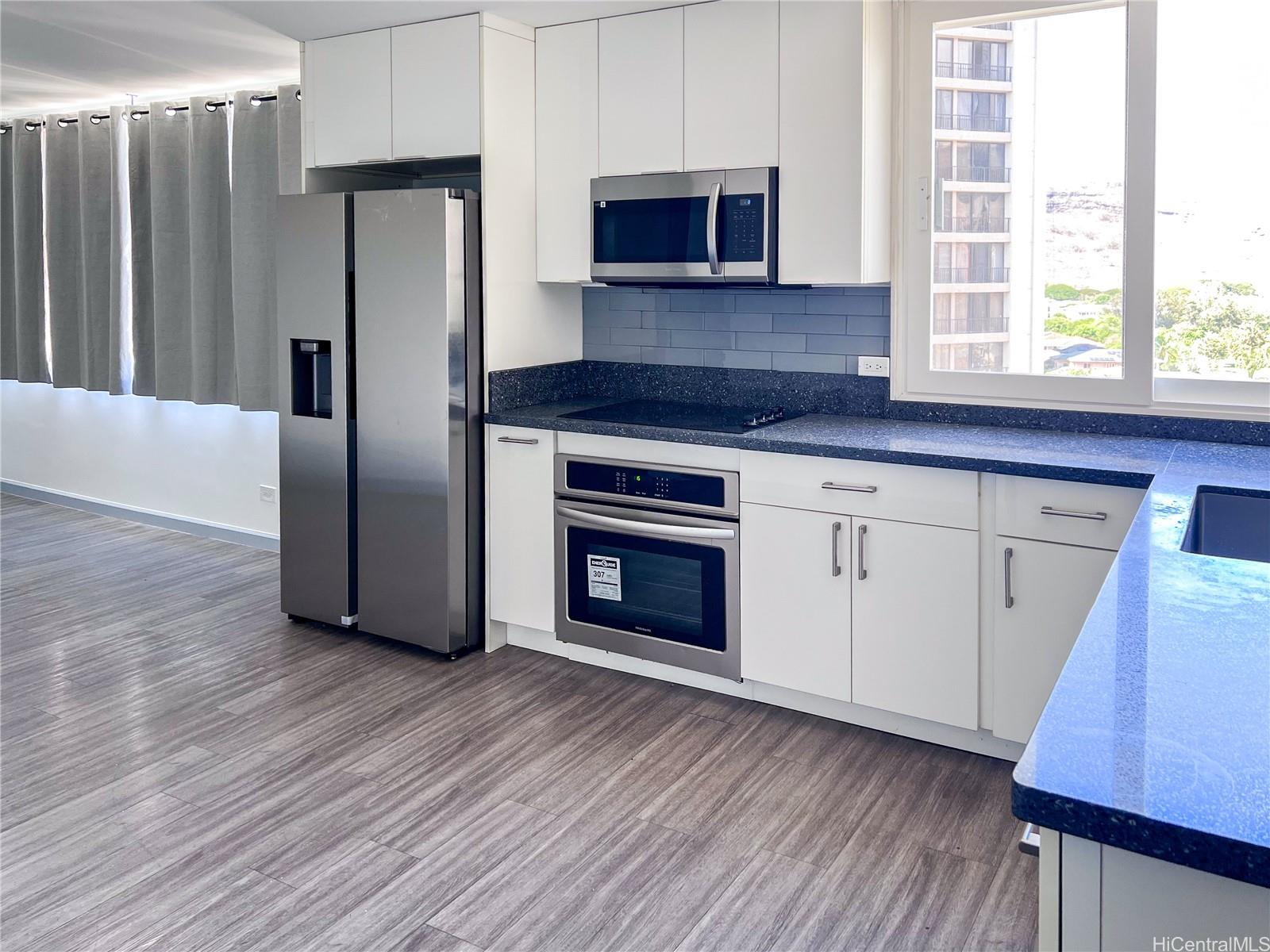 5210 Likini Street, Unit 901 Honolulu, HI 96818 - Photo 2 of 16 a kitchen with granite countertop a refrigerator and a stove top oven