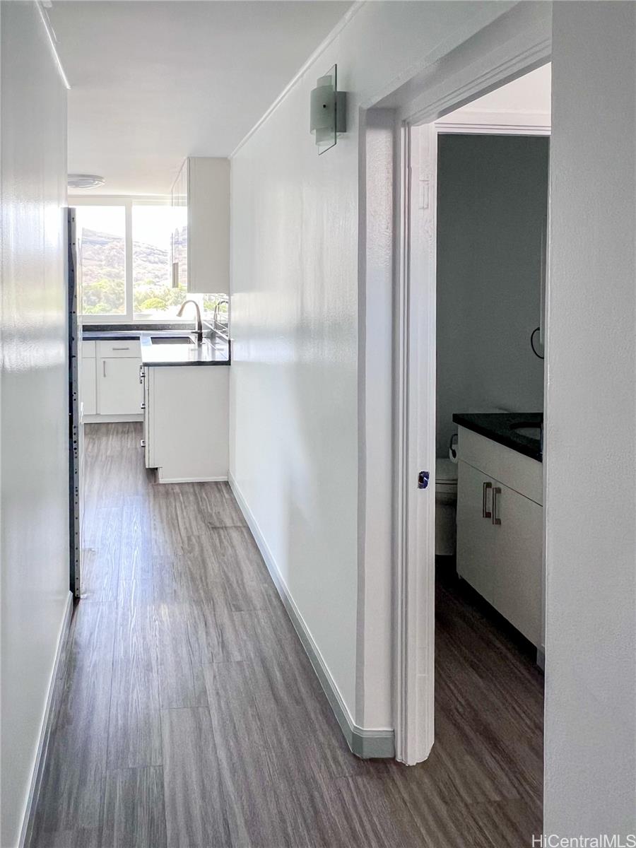 5210 Likini Street, Unit 901 Honolulu, HI 96818 - Photo 5 of 16 a kitchen with kitchen island wooden floors white appliances and sink