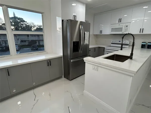a kitchen with a refrigerator sink and cabinets