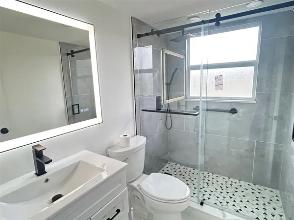 a bathroom with a sink a toilet and shower