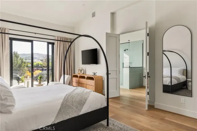 a bedroom with a bed and a large mirror next to a large window