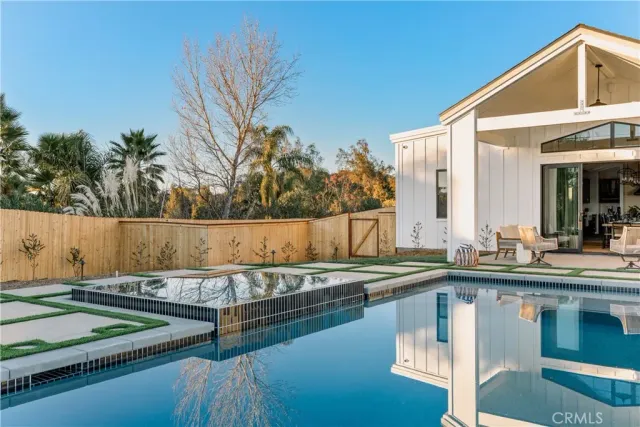 a view of a house with pool and sitting area