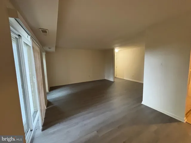 an empty room with wooden floor and entrance