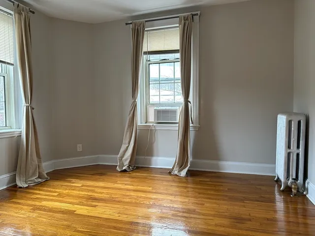 a view of a room with wooden floor and a window