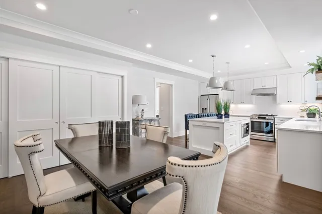 a kitchen with a table chairs and white cabinets