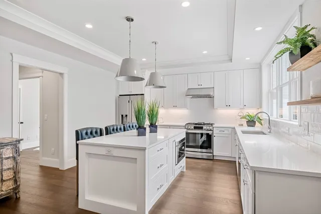 a large white kitchen with a stove and refrigerator