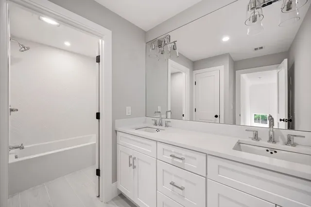a bathroom with a sink and a mirror with shower