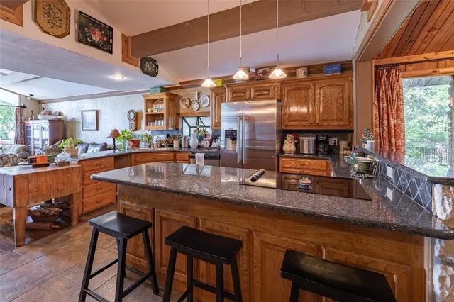 a kitchen with stainless steel appliances granite countertop table chairs sink and cabinets