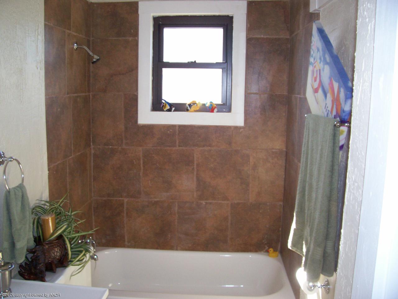 3901 South Polk Street Amarillo, TX 79110 - Photo 4 of 8 a bathroom with a bathtub and window