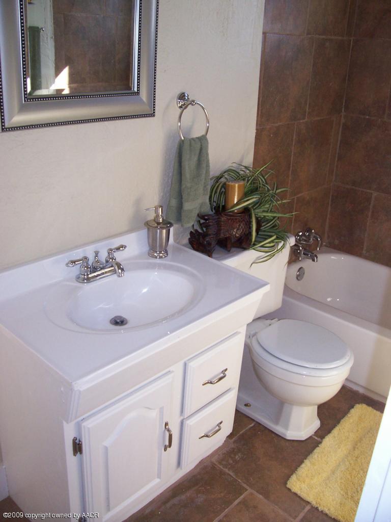 3901 South Polk Street Amarillo, TX 79110 - Photo 5 of 8 a bathroom with a sink toilet and mirror
