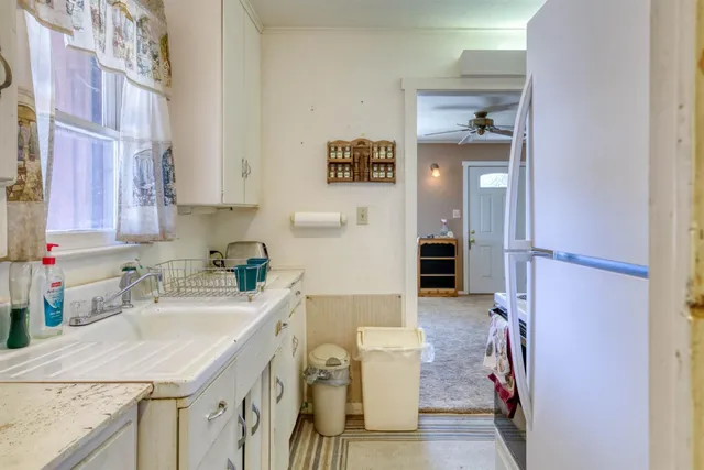 a kitchen with a sink refrigerator and cabinets
