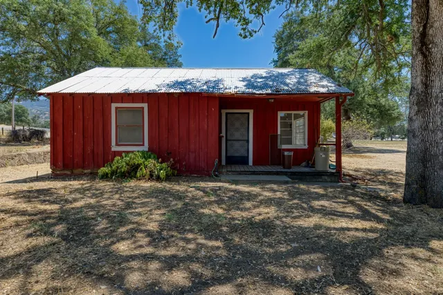 a view of a house with a tree in front of it
