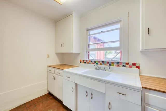 a kitchen with a sink cabinets appliances and a window