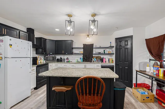 a kitchen with stainless steel appliances granite countertop a sink refrigerator and microwave