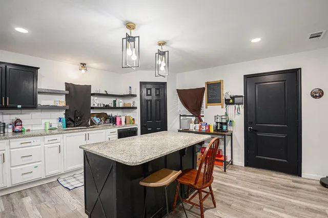 a kitchen with a refrigerator a microwave a stove and wooden floor