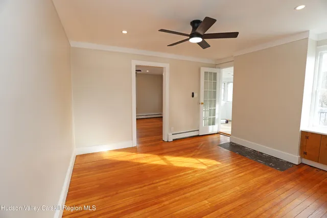 a view of a room with wooden floor and a ceiling fan