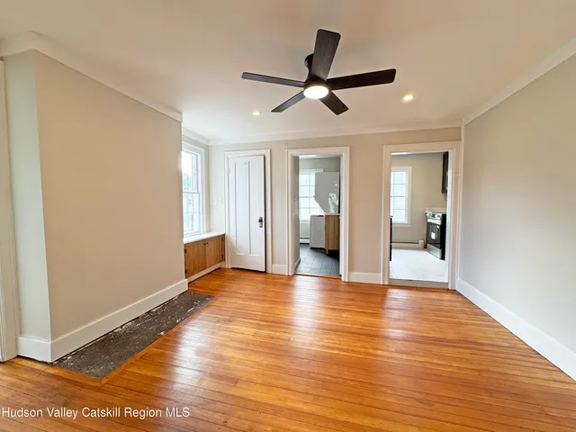 a view of a livingroom with a ceiling fan and wooden floor