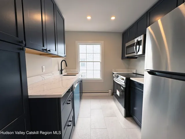 a kitchen with stainless steel appliances granite countertop a sink a stove and a refrigerator