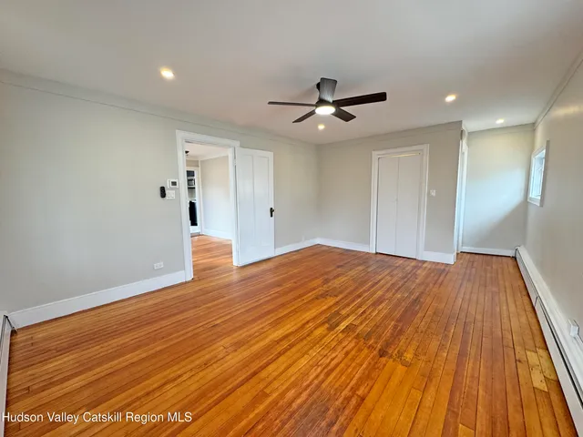 a view of empty room with wooden floor