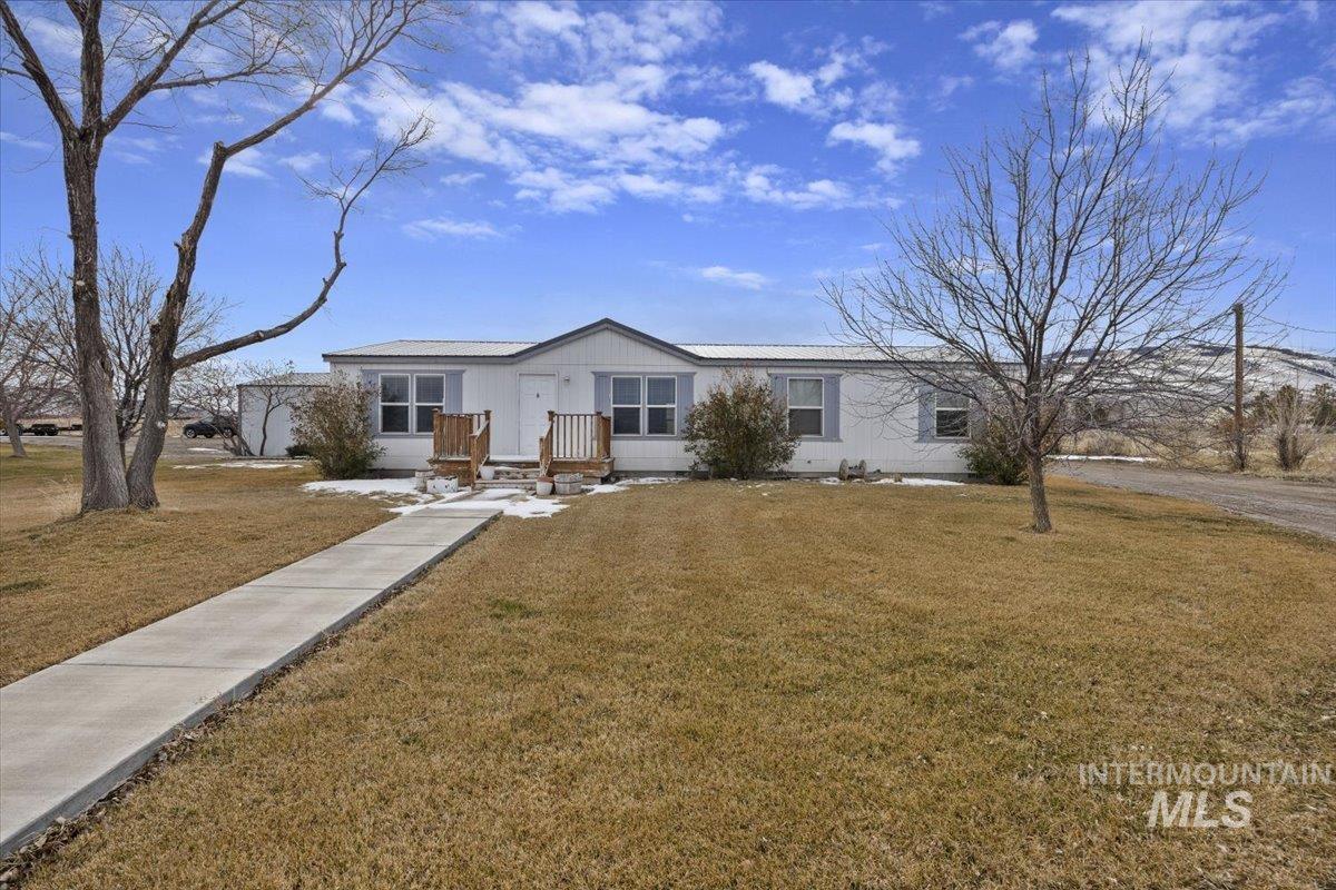 View of front of home with a front lawn and solar panels