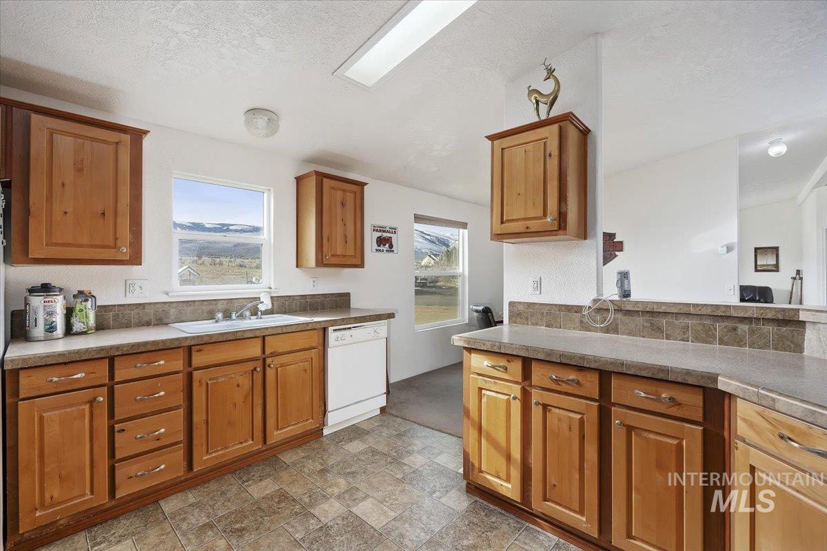 1014 S Highway Albion, ID 83311 - Photo 11 of 34 Kitchen with wood finish cabinets, stone finish floors, plenty of natural light, and a textured ceiling