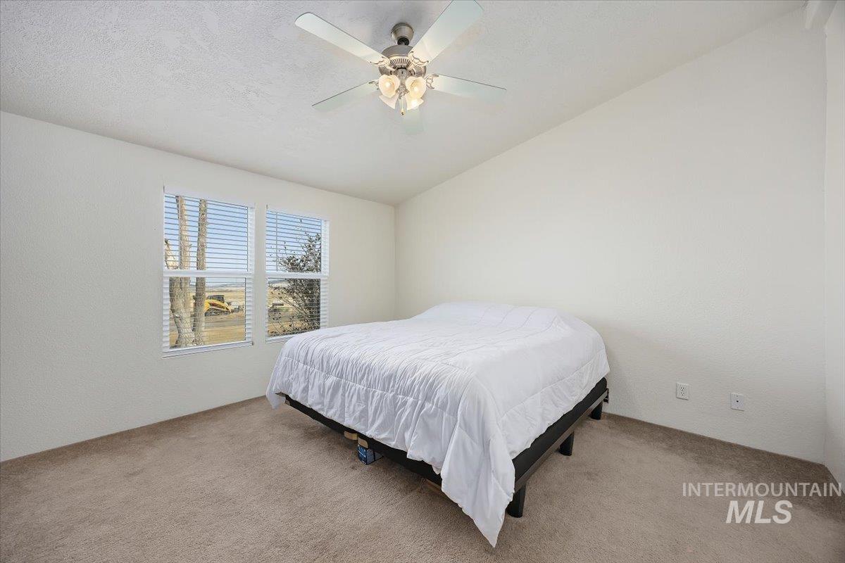 1014 S Highway Albion, ID 83311 - Photo 17 of 34 Carpeted bedroom featuring lofted ceiling, ceiling fan, and a textured wall