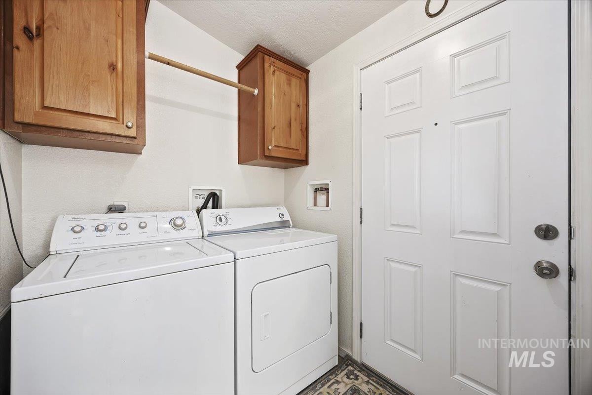 1014 S Highway Albion, ID 83311 - Photo 26 of 34 Laundry area featuring washer and dryer, a textured ceiling, and cabinet space
