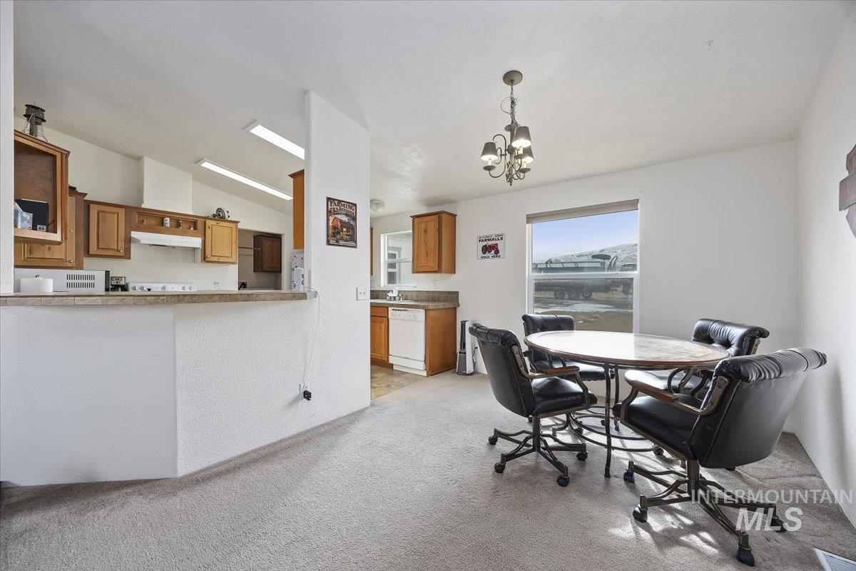 1014 S Highway Albion, ID 83311 - Photo 7 of 34 Dining space with lofted ceiling, light colored carpet, and hanging lights