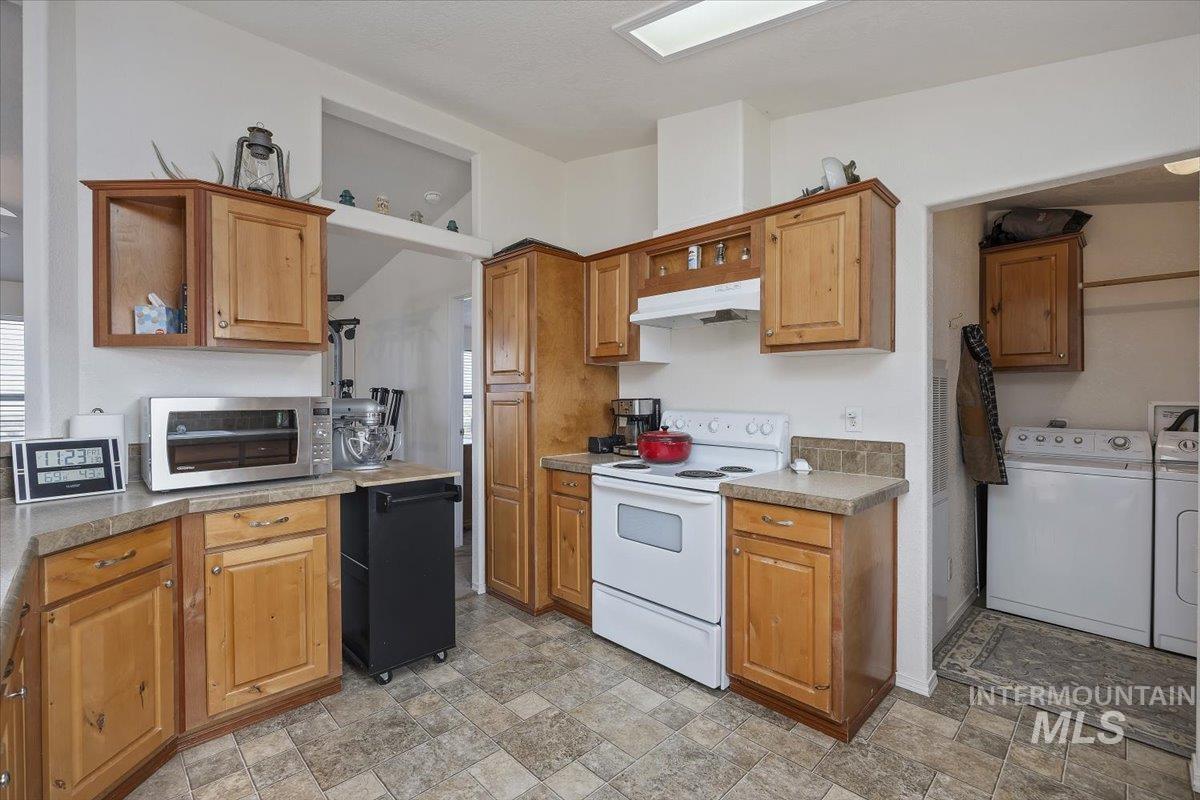 1014 S Highway Albion, ID 83311 - Photo 9 of 34 Kitchen featuring stone finish floors, white range with electric stovetop, wood finish cabinets, and stainless steel microwave