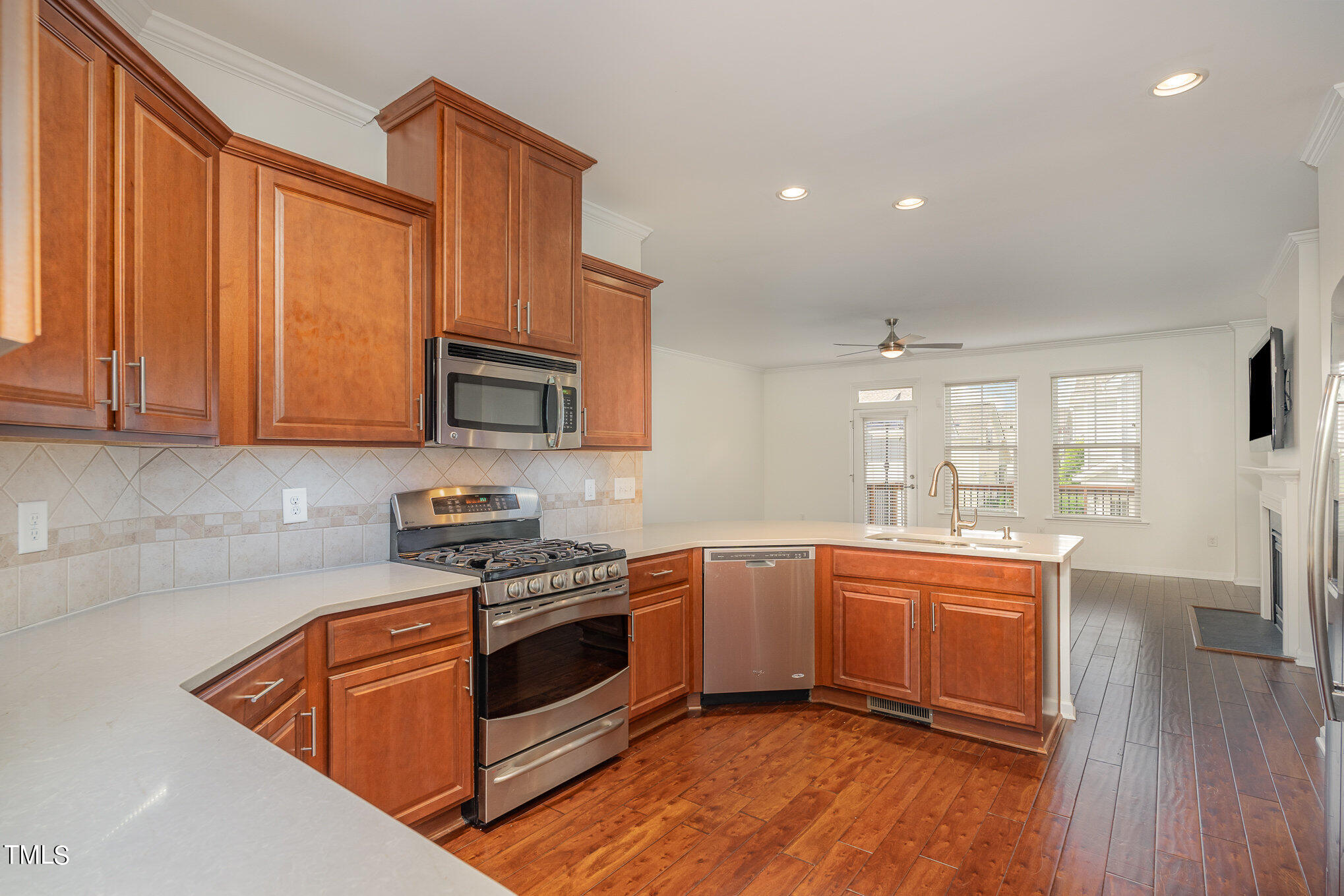 1435 Van Page Boulevard Raleigh, NC 27607 - Photo 18 of 41 a kitchen with stainless steel appliances granite countertop wooden floors and white cabinets