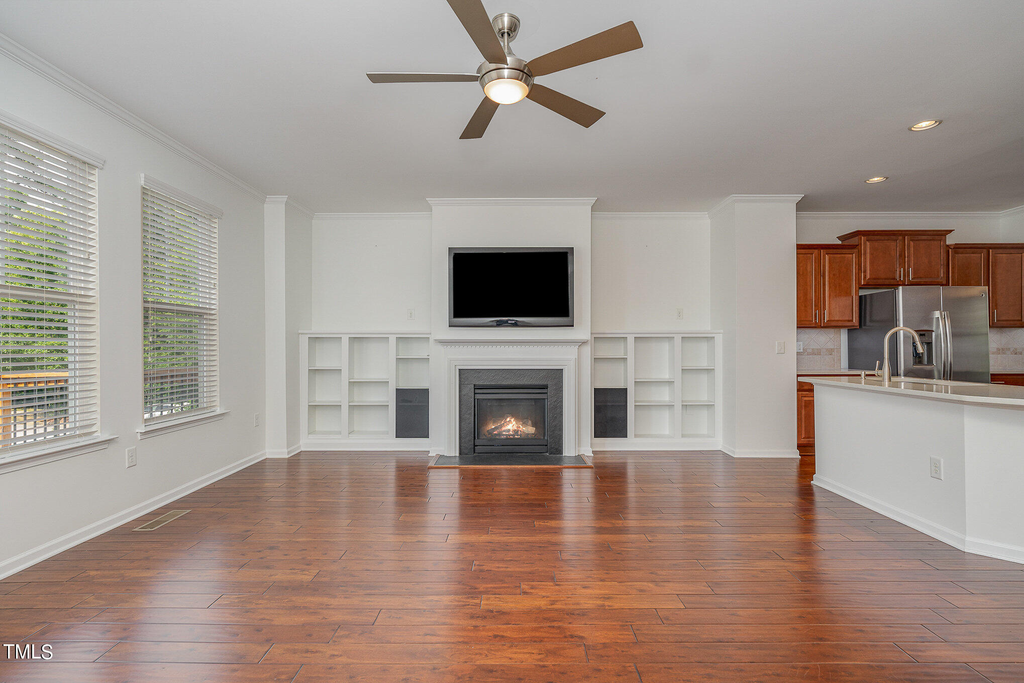 1435 Van Page Boulevard Raleigh, NC 27607 - Photo 22 of 41 a view of a livingroom with a fireplace a ceiling fan and windows