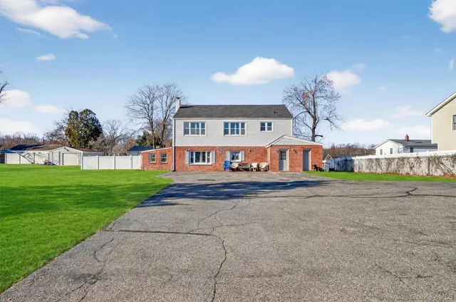 a view of a big house with a big yard and large trees
