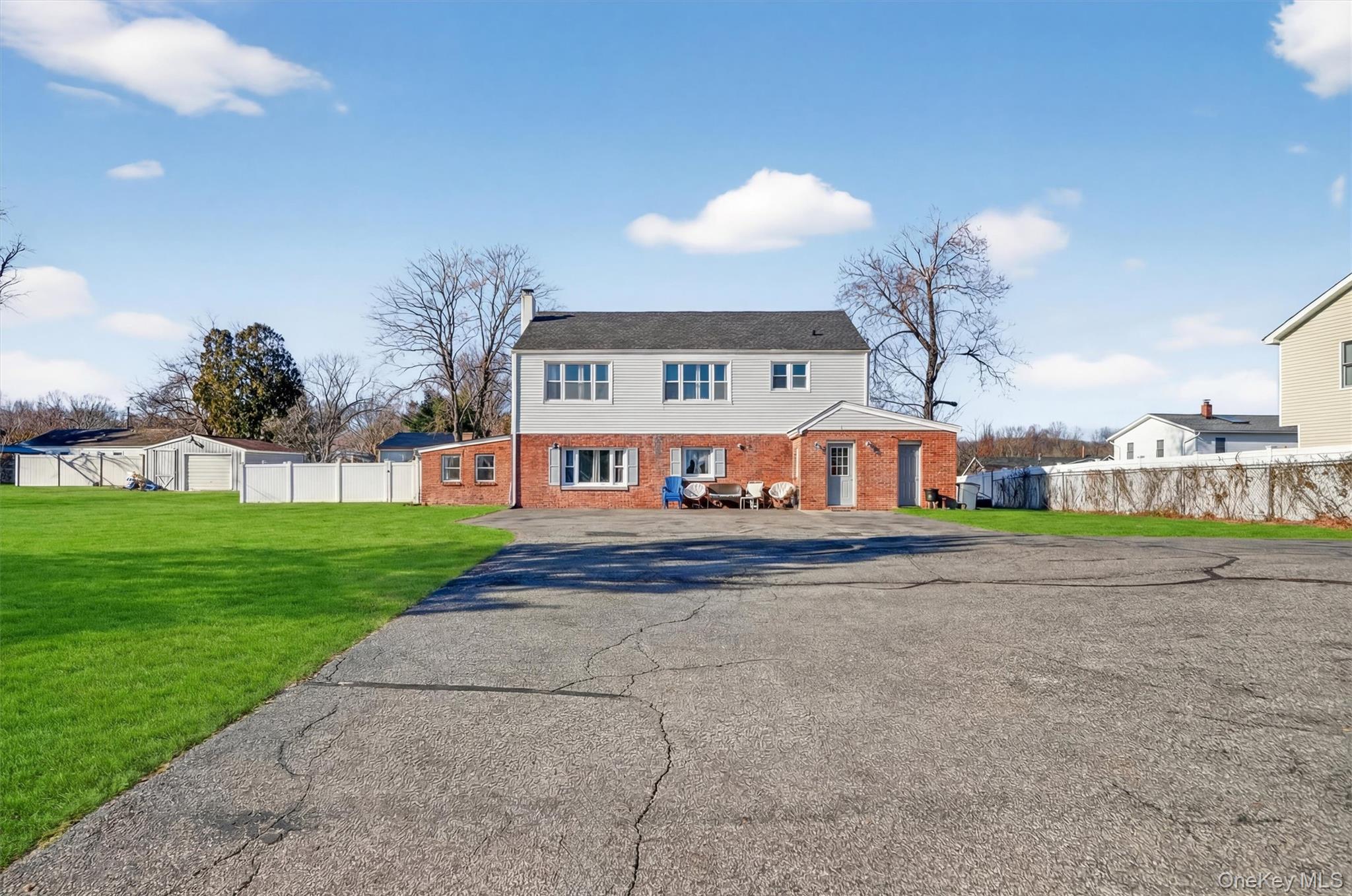 a view of a big house with a big yard and large trees