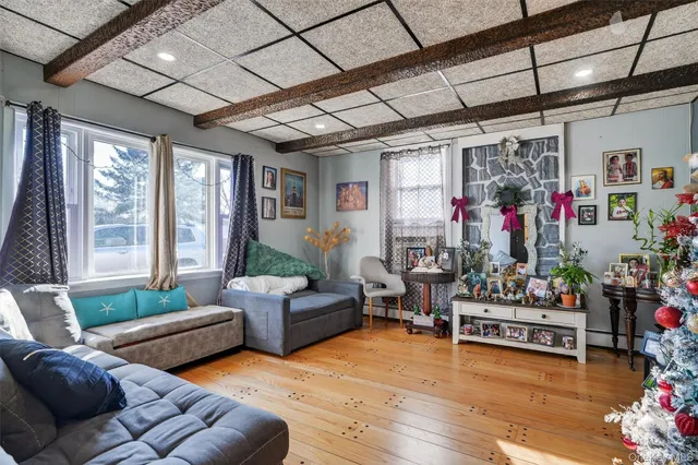 a living room with furniture and a dining table with wooden floor