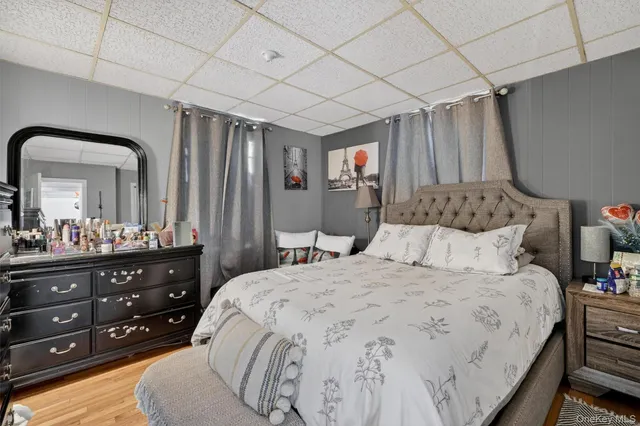 a bedroom with a bed a mirror on dresser and a chandelier