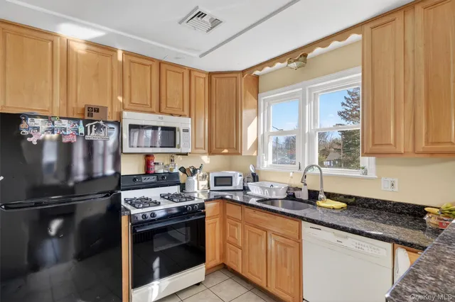 a kitchen with granite countertop a sink stainless steel appliances and cabinets