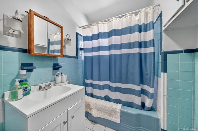 a bedroom with a bed and a flat tv screen on dresser