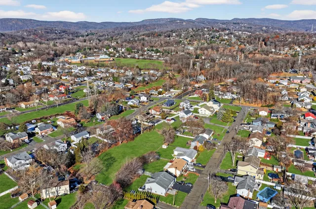 an aerial view of a city with lots of residential buildings and mountain view in back