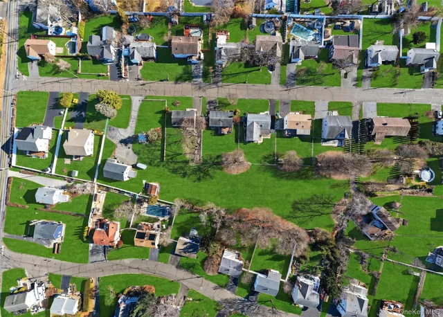 an aerial view of residential houses with outdoor space and trees