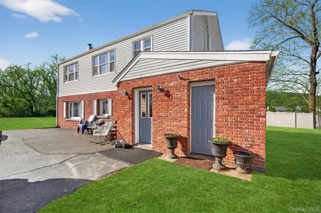 a view of a house with a yard and sitting area